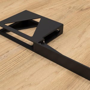 May include: Black metal shelf bracket with a triangular cutout and a long, straight arm extending from the side. The bracket is designed to support a shelf or other object.