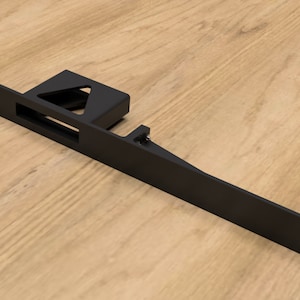 May include: Black metal bracket with a rectangular cutout and a triangular shape on the left side. The bracket has multiple holes on the top and bottom.