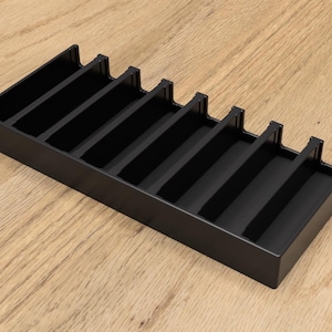 May include: Black plastic organizer with eight compartments for storing small items.