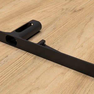 Peut inclure: Support métallique noir avec une base rectangulaire longue et une section cylindrique verticale. Le support comporte plusieurs trous pour le montage.