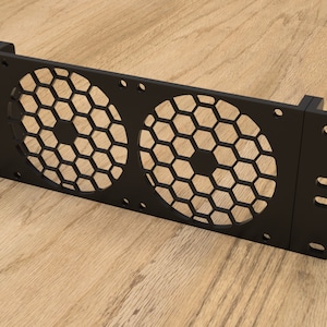 Puede incluir: Estante de metal negro con dos rejillas de ventilador de malla hexagonal. El estante tiene orificios de montaje en los lados y la parte superior.