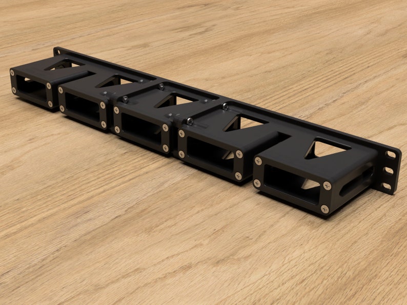 May include: A black metal rack with multiple slots for holding items. The rack has a series of triangular cutouts and is secured with screws.