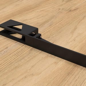 Könnte beinhalten: Schwarze Metallhalterung mit einem rechteckigen und einem dreieckigen Ausschnitt. Die Halterung ist für die Montage an einer Wand oder einer anderen Oberfläche konzipiert.