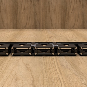 May include: A black metal rack with five compartments for holding items. The rack is mounted on a wooden surface.