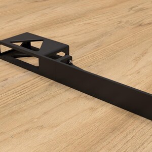 Peut inclure: Support métallique noir avec une ouverture rectangulaire et une petite découpe triangulaire. Le support comporte une série de trous sur un bord.