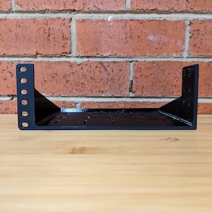 May include: Black metal rack shelf for mounting equipment in a server rack.