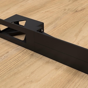 May include: Black metal rack with a rectangular opening and multiple holes along the sides. The rack is designed to hold and secure equipment.