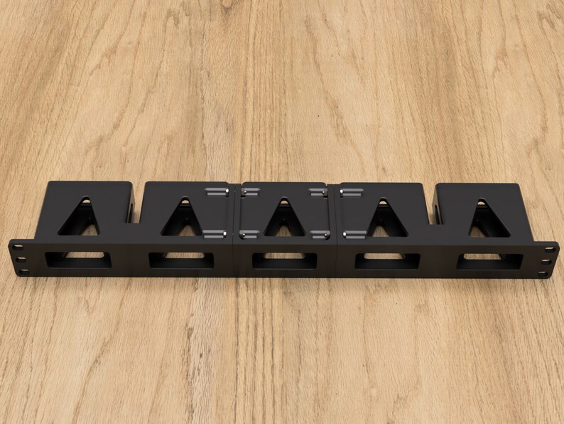 May include: Black metal cable management rack with five compartments for organizing cables. The rack has a rectangular shape and is designed to be mounted on a wall or surface.