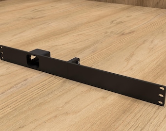 May include: A black metal door latch with a rectangular design. The latch has a central opening and is mounted on a wooden surface. The latch has three holes on each end.