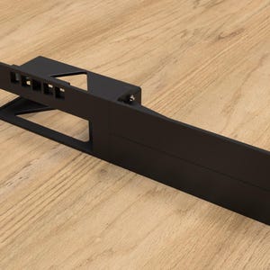 May include: Black metal rack with multiple slots and holes. The rack is designed to hold and organize items.