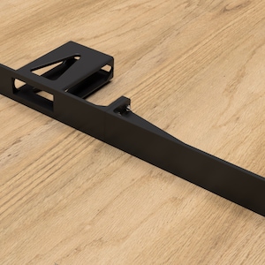 Peut inclure: Support métallique noir de forme rectangulaire avec une petite section surélevée à une extrémité. Le support comporte plusieurs trous pour le montage.