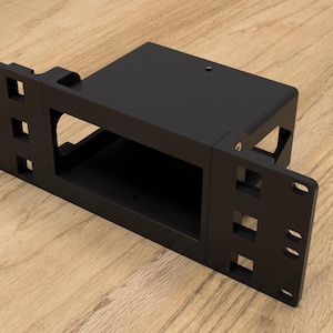 May include: Black metal wall mount bracket with a rectangular opening. The bracket has a series of slots on both sides.