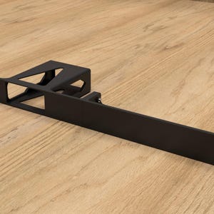 Peut inclure: Un support métallique noir avec une base rectangulaire et une structure de support à angle droit. Le support comporte des formes découpées et des trous de montage. Le support est conçu pour le montage d'équipement.