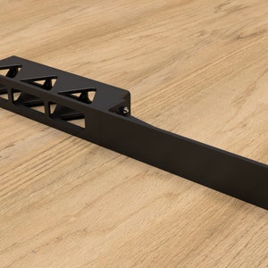 May include: Black metal rack with triangular cutouts. The rack is designed to hold multiple items and has a long, flat extension on one side.