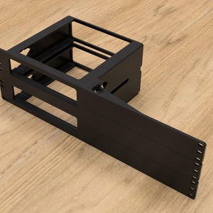 May include: A black metal computer case frame with a rectangular design. The frame has multiple openings and a side panel that extends outward. The case is designed to hold computer components.