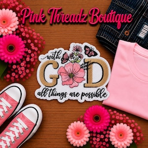 Puede incluir: Un parche bordado blanco con el texto 'with GOD all things are possible' en negro y dorado, decorado con flores rosas y mariposas. El parche está rodeado de gerberas rosas, zapatillas deportivas rosas y una camiseta rosa.