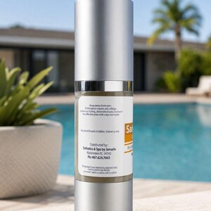 May include: A cylindrical pump bottle with a silver cap and base, containing a beige liquid. The white label features the text 'Distributed by: Esthetics & Spa by Jamarie, Kissimmee FL 34743, Ph: 407.624.7063' along with safety warnings and product information.