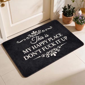 Puede incluir: Felpudo rectangular negro con texto blanco: "This is MY HAPPY PLACE DON'T FUCK IT UP". La alfombra tiene adornos decorativos. Un felpudo humorístico para el hogar.