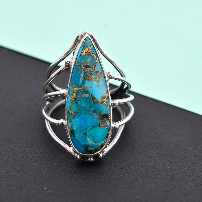 Turquoise is considered as a calming stone. Copper Turquoise teardrop multi-band ring made up of 92.5 Sterling Silver