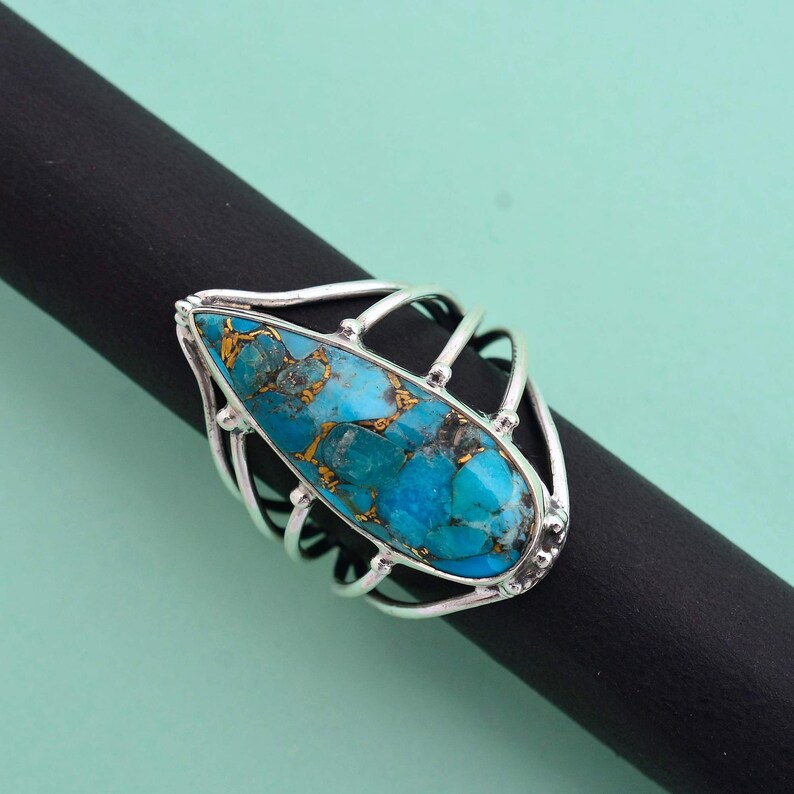 Turquoise is considered as a calming stone. Copper Turquoise teardrop multi-band ring made up of 92.5 Sterling Silver