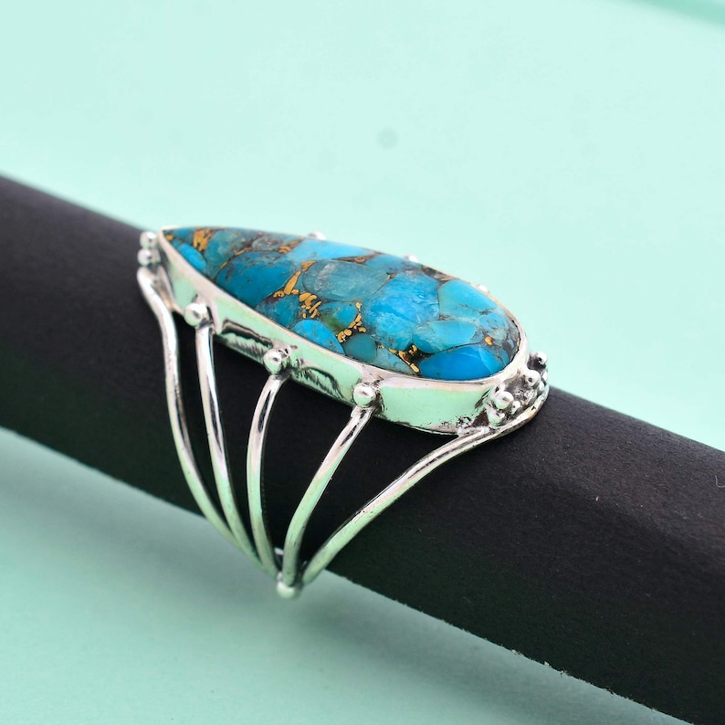 Turquoise is considered as a calming stone. Copper Turquoise teardrop multi-band ring made up of 92.5 Sterling Silver