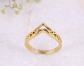 May include: A gold filigree ring with a V-shaped opening in the center.
