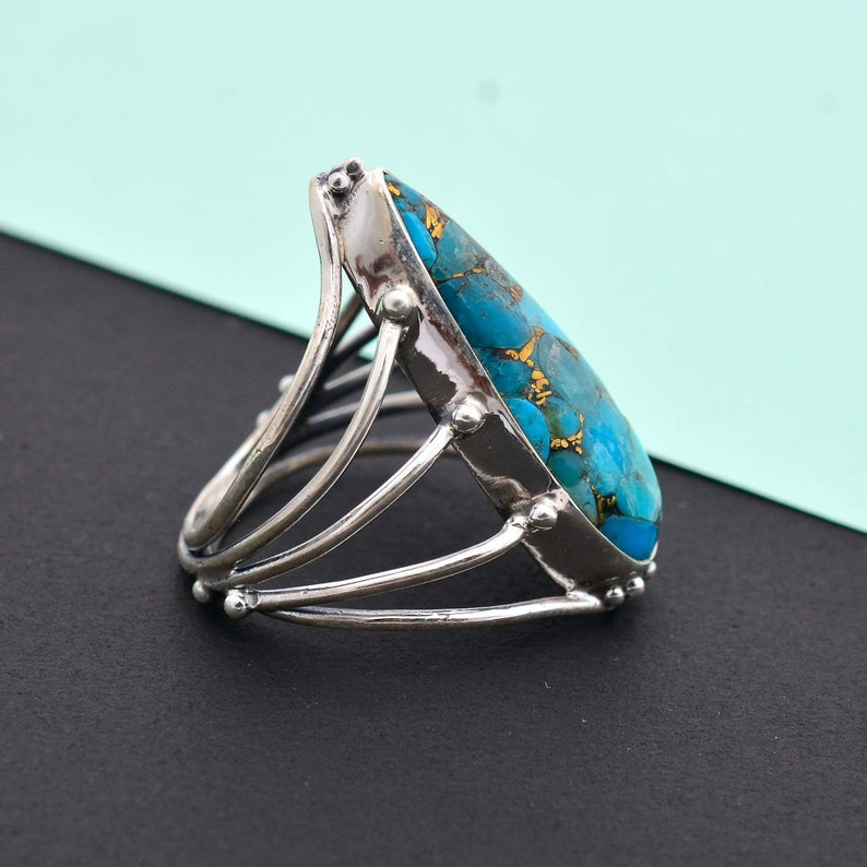 Turquoise is considered as a calming stone. Copper Turquoise teardrop multi-band ring made up of 92.5 Sterling Silver