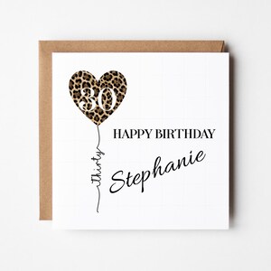 May include: A square white greeting card featuring a heart-shaped balloon with a brown and black leopard print pattern containing the white number 30. The text reads HAPPY BIRTHDAY and Stephanie, with the word thirty written along the balloon string.