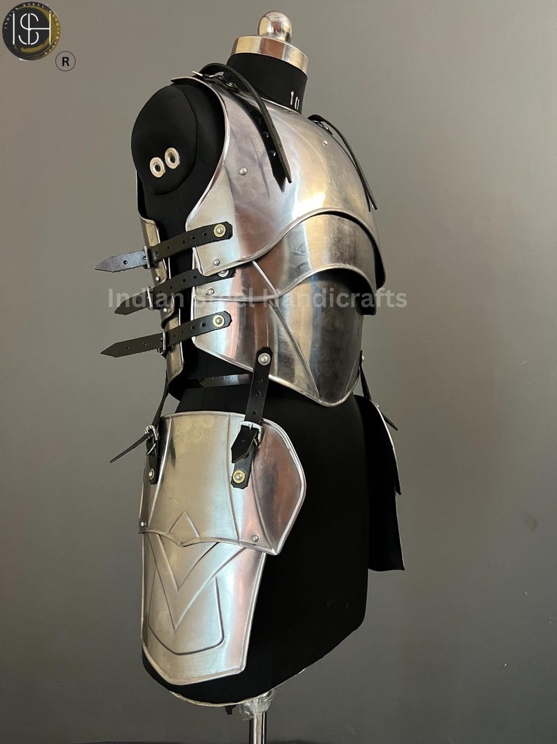 May include: Silver-toned metal armor for the chest and legs, with straps and buckles. The armor is displayed on a black mannequin.