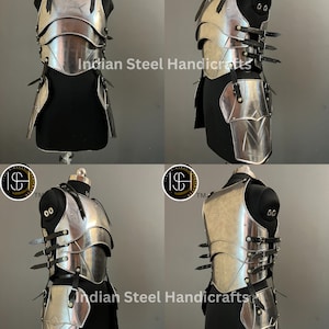 May include: A silver metal breastplate and skirt armor set with black leather straps. The armor is displayed on a mannequin. The image includes the text "Indian Steel Handicrafts" and "ISH TM".
