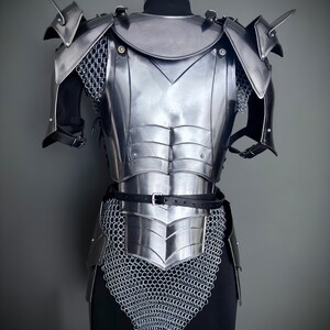 Peut inclure: Armure plaqu&eacute;e argent avec cotte de mailles, ceinture en cuir et &eacute;pauli&egrave;res pointues. L'armure est expos&eacute;e sur un mannequin.