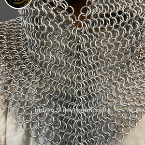 May include: A silver chainmail collar, made of interlocking metal rings. The collar is a traditional piece of armour, often worn for historical reenactment or cosplay.