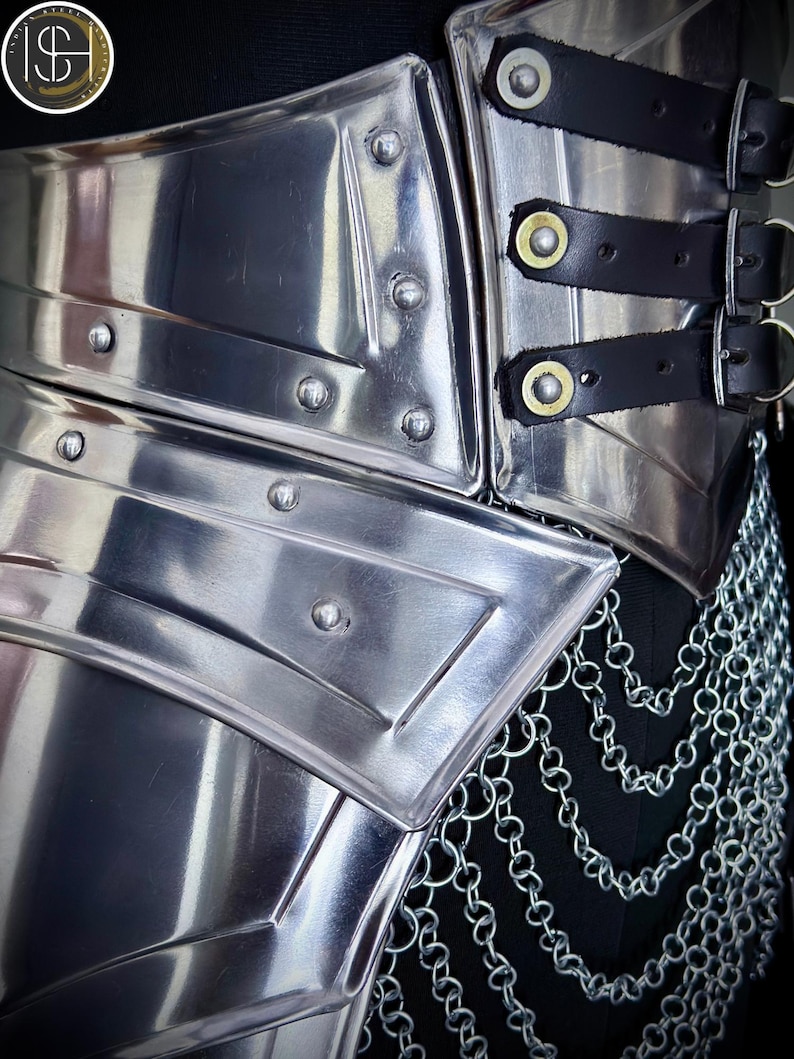 K&ouml;nnte beinhalten: Nahaufnahme einer polierten Metallr&uuml;stung mit genieteten Details und schwarzen Lederriemen. Die R&uuml;stung verf&uuml;gt &uuml;ber einen Kettenrock und ist zum Schutz des Torsos konzipiert. Das Metall hat eine reflektierende Oberfl&auml;che und erinnert an mittelalterliche R&uuml;stungen.