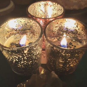 Pu&ograve; includere: Tre portacandele in vetro color oro con fiamme tremolanti all'interno. I portacandele hanno una superficie testurizzata punteggiata.