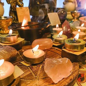 Pu&ograve; includere: Un altare di legno con una variet&agrave; di cristalli, candele e incenso. L'altare &egrave; decorato con un pentagramma e altri simboli. Ci sono diverse candele a tea light accese sull'altare e un piccolo calderone con incenso che brucia al suo interno.
