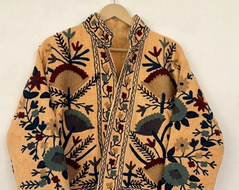 May include: A beige embroidered jacket with a floral pattern in shades of blue, green, red, and brown. The jacket has a mandarin collar and a button closure.