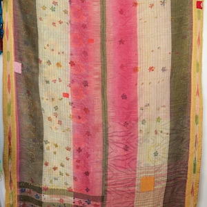 Puede incluir: Textil a rayas verticales con diseño de patchwork. El edredón presenta rayas alternas de color rosa, crema y marrón, adornadas con motivos florales. Los bordes están ribeteados con un borde amarillo.