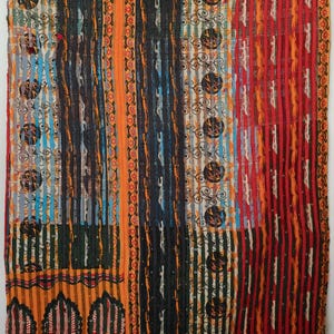 May include: A rectangular textile quilt featuring vertical panels with diverse patterns including black circles, thin stripes, and floral motifs in vibrant shades of red, orange, yellow, blue, and black, finished with visible running stitch quilting.