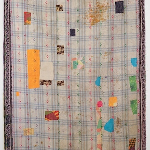 Puede incluir: Un edredón patchwork vintage con un patrón de cuadros gris claro y parches coloridos. El edredón tiene un borde morado oscuro y está adornado con varios parches rectangulares y cuadrados en tonos naranja, azul, verde y rojo.