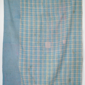 May include: A blue and white checkered fabric with a faded appearance. The fabric is made of thin cotton and has a soft texture.