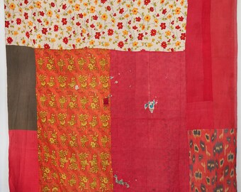 May include: A rectangular patchwork quilt featuring a variety of fabric panels in shades of red, turquoise, and brown. The design includes sections with floral patterns in red and yellow, as well as a section with a dark blue and red abstract print.