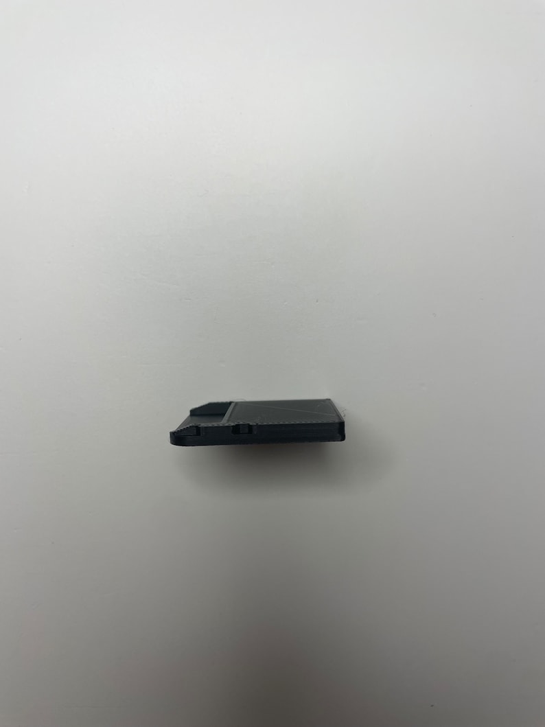 May include: A black floppy disk with a label on the front.