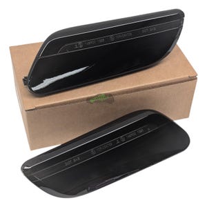 Puede incluir: Se muestran dos luces de posición laterales negras para coche, con un acabado brillante, ligeramente anguladas. Cada luz tiene el texto "DOT SAE" y otras marcas. Se colocan sobre una caja de cartón marrón.