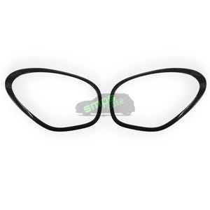 May include: Two black, oval-shaped car headlight covers with a carbon fiber texture. The covers are positioned side-by-side against a white background. The text "SMO 2012" is visible in the center.