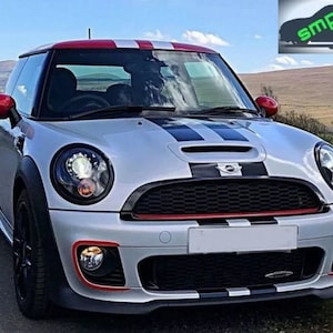 May include: A silver Mini Cooper with black and red racing stripes. The car has black wheels and a black grille with a Mini logo.