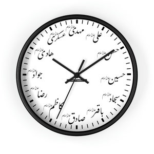 Könnte beinhalten: Eine runde Wanduhr mit schwarzem Rahmen und weißem Zifferblatt. Die Uhr hat schwarze Zeiger und arabische Kalligraphie am Rand. Das Zifferblatt hat ein minimalistisches Design mit schwarzen Markierungen für die Stunden.