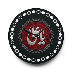 Könnte beinhalten: Runde schwarze Wanduhr mit rotem Blumendesign in der Mitte. Das Zifferblatt zeigt silberne arabische Schrift und schwarze Zeiger. Der äußere Rand hat ein weißes gepunktetes Muster.