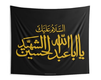 Könnte beinhalten: Schwarzes Wandbehang mit goldener arabischer Kalligraphie. Der Text lautet "Ya Aba Abdillah Al-Hussein" in einer stilisierten Schrift. Der Wandteppich ist rechteckig und hängt vor einem weißen Hintergrund.