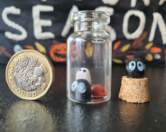 Demone interno catturato in una bottiglia di vetro con un fantasma e una zucca, diorama di Halloween. Mini bottiglia