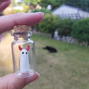 Mały duch diabeł w miniaturowej szklanej butelce. Halloween